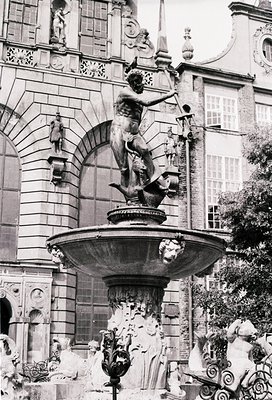 Baroque-style fountain featuring a central male figure treading a sea creature, surrounded by intricate carvings and decorati...