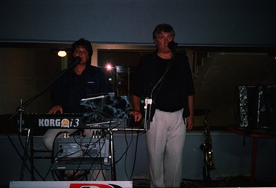 Two musicians performing live on stage, 1980s–1990s era. Left: keyboardist playing a Korg Poly-800i synth, right: saxophonist...