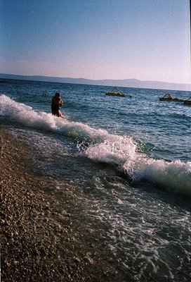 Surfer riding a powerful wave in mid-air, framed by turbulent ocean foam. Dynamic composition captures motion and raw energy....