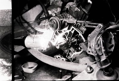 Close-up of a vintage motorcycle engine with exposed valve train, carburetor, and flywheel. Distinctive dual overhead valves ...