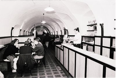 Vintage underground café with curved, arched ceiling and checkered floor. Mid-20th century interior features curved benches, ...