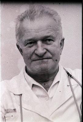 Portrait of an elderly man in a white lab coat, likely a doctor or scientist, mid-20th century. His stethoscope draped around...