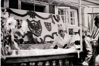 Industrial-era food processing facility featuring workers in white uniforms and hairnets. Central figure handles large, coile...