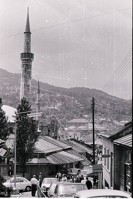 Black-and-white street scene featuring Ottoman-style minarets and domes in a hilly town, likely or . Mid-20th century archite...