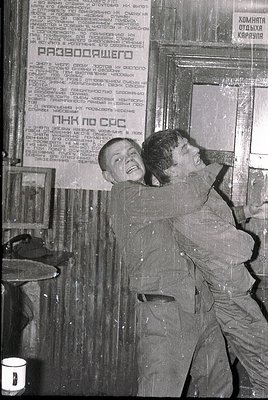 Black-and-white photo of two men in heavy work uniforms (likely miners) leaning against a wall with Cyrillic text—likely Bulg...