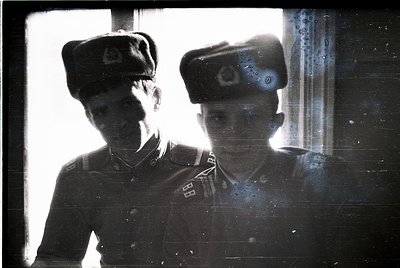 Vintage sepia-toned portrait of two uniformed individuals in Soviet-era military caps, likely 1940s–1950s. Distinctive red st...