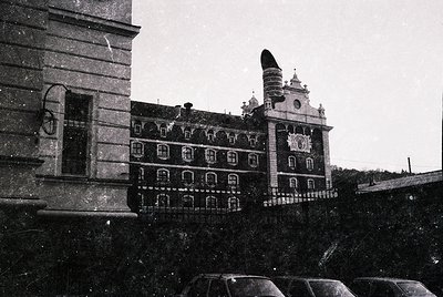 Historic grand building with ornate Baroque façade, featuring a central clock tower and decorative stonework. Snow blankets r...