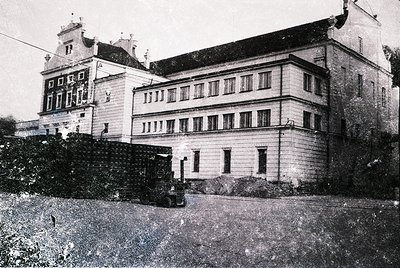 Three-story historic building with symmetrical façade, featuring tall rectangular windows and decorative gables. Likely early...