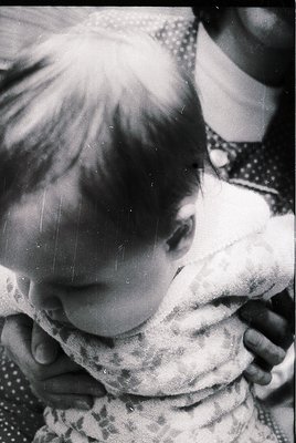 Close-up of a child in mid-laugh, sunlight streaming through hair. Patterned fabric (likely a dress) with subtle polka dots. ...