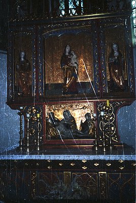 Baroque-style altar piece featuring gilded woodwork, intricate carvings, and religious iconography. Central panel depicts Chr...