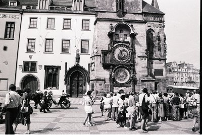 Historic Prague square featuring the Astronomical Clock Tower (Orloj) with medieval architecture. Crowds gather around the or...