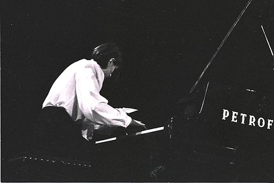 Black-and-white concert shot of pianist performing at the **Petrof** venue, likely **Petrofka Hall** (St. Petersburg, Russia)...