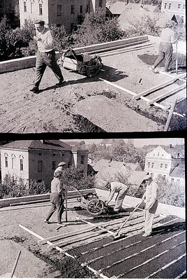 Black-and-white construction scene featuring three laborers assembling wooden planks on a rooftop terrace, likely for a flat ...