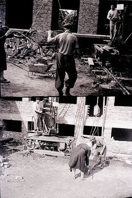 Mid-20th century construction site featuring brickwork and heavy machinery. Workers in utilitarian clothing operate cranes, l...