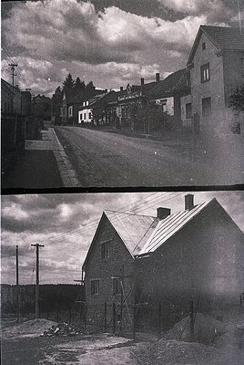Vintage black-and-white street scene showing modest, single-story homes with pitched roofs and small gardens, likely from the...