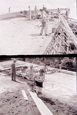 Mid-20th century construction site featuring wooden dock or pier assembly. Workers in rolled-up sleeves and caps secure plank...