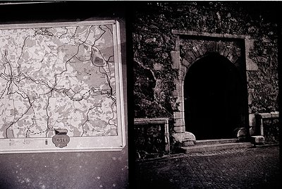 Black-and-white archival photo of a framed vintage map (1960s-70s) depicting a region with detailed road networks, overlaid o...