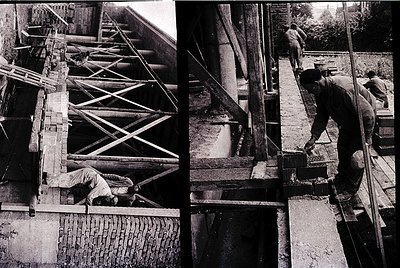 Black-and-white construction scene featuring three workers assembling wooden scaffolding and brickwork, likely mid-20th centu...