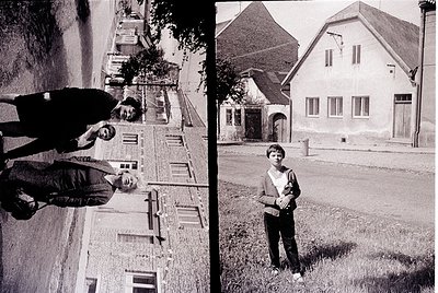 Black-and-white split image capturing mid-20th century European street life. Left: Two men pose on a narrow alleyway lined wi...