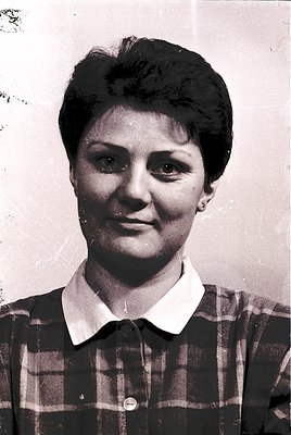 Vintage black-and-white portrait of a woman in a plaid blouse, short hairstyle, and earrings. Likely a mid-20th-century ID or...