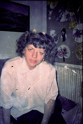 Vintage portrait through frosted glass, capturing a woman in a voluminous 1960s-style sweater with a curly hairstyle. Decorat...