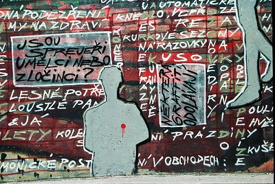 Graffiti mural featuring a black silhouette of a person with a red heart over their chest, set against a faded, red-painted w...