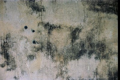 Close-up of textured concrete wall with visible cracks, stains, and minor pitting. Likely industrial or urban architecture, s...