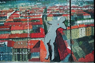 Vibrant mural-style artwork depicting a lone figure in mid-jump against a chaotic urban backdrop of red-brick buildings and t...