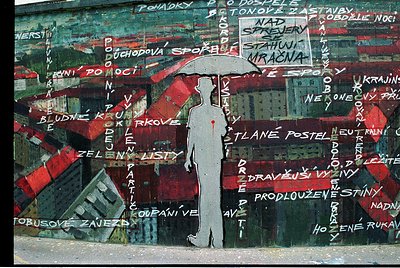Street mural featuring a silhouetted figure holding a red umbrella against a backdrop of fragmented Czech/Czech-inspired text...