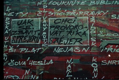 Vibrant graffiti on weathered concrete wall with Czech/Slovak text. Prominent phrases include *"CHCI PROVOKOVAT RÍKU"* ("I wa...