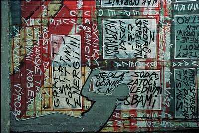 Vibrant graffiti-covered wall featuring layered Cyrillic text in red, white, and black ink. Prominent phrases include *"Jedla...