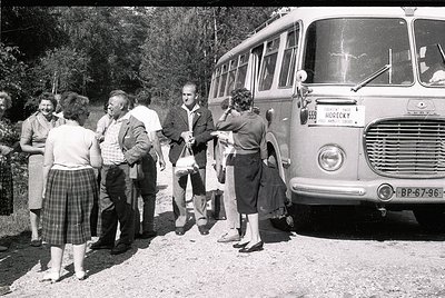 Vintage group boarding a **Horecky** branded bus (license plate BP-67-96) in mid-20th century, likely 1960s. Six adults in pe...