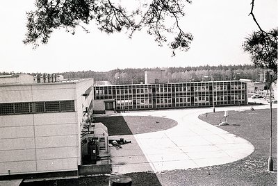 Mid-century Brutalist-style institutional building with exposed concrete and grid-patterned windows, likely a university or g...