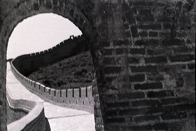 Close-up of a vintage measuring tape wrapped around a brick archway, showcasing its scale markings. The brickwork suggests in...