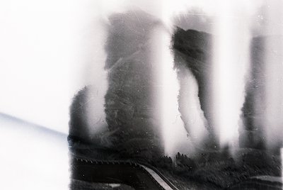 Vintage monochrome photo of blurred industrial pipes and machinery, likely from a factory or power plant. Distinctive riveted...