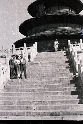 Three men pose on wide stone steps leading to the multi-tiered Hall of Prayer for Good Harvests, Temple of Heaven, Beijing. M...