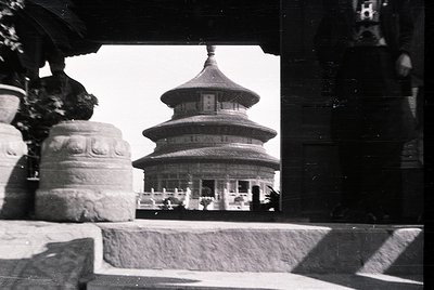 Classic three-tiered pagoda framed by stone window ledge, likely . Mid-20th century black-and-white shot captures traditional...