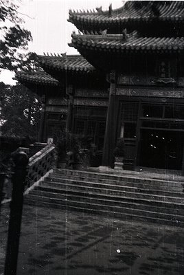 Classic Chinese temple staircase with tiered pagoda roof, intricate wooden carvings, and stone balustrade. Likely architectur...