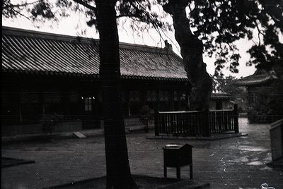 Black-and-white courtyard featuring traditional East Asian architecture with tiled roofs and wooden beams. Open pavilion with...