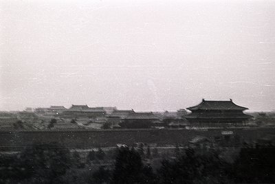 Vintage black-and-white photo of traditional East Asian palace architecture with tiled roofs and curved eaves, likely from th...