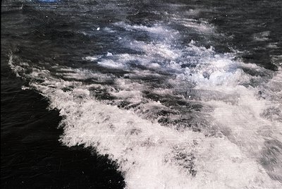 High-contrast monochrome shot of turbulent ocean waves crashing against a rocky shore. Dramatic texture captures frothy white...