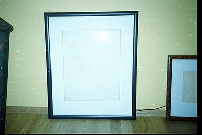 Empty black-framed canvas on textured wall, minimalist interior. Empty frame suggests potential for art display or design stu...