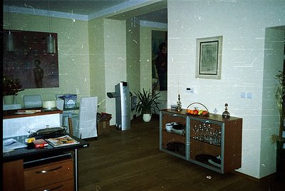 Vintage mid-century interior featuring light-colored linoleum floors and built-in wooden cabinetry. A retro radio/cassette pl...
