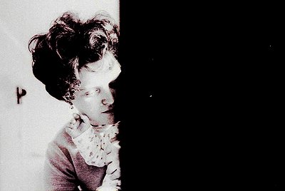 Vintage sepia-toned portrait of a woman with voluminous 1920s-style curls, clutching a lace-trimmed handkerchief. Dramatic li...