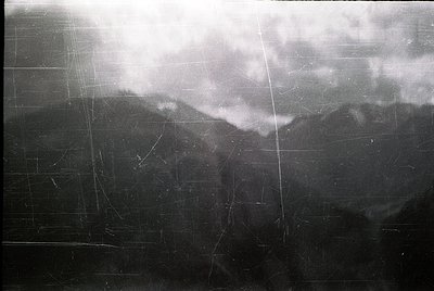 Vintage black-and-white aerial view of a grid-patterned agricultural field with faintly visible furrows, likely plowed for cr...
