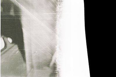 Vintage sepia-toned close-up of a person’s profile, partially obscured by scratches and fading. Likely a mid-20th century por...