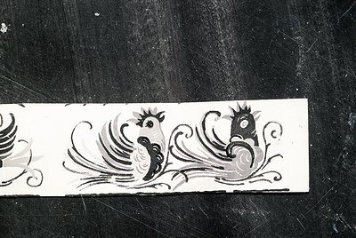 Black-and-white decorative frieze featuring stylized rooster motifs with ornate scrollwork, likely from a 19th–20th century E...