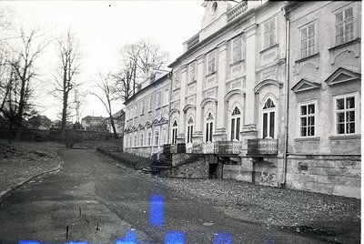 Neoclassical building with arched windows and decorative cornices, likely from the early-to-mid 20th century. Symmetrical faç...