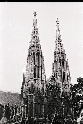 Gothic twin spires with intricate tracery and pointed arches, likely part of a 14th-century cathedral. The facade features a ...