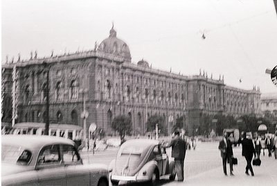 Vienna’s grand **Hofburg Imperial Palace** dominates this mid-20th century street scene, showcasing its Baroque façade and ce...